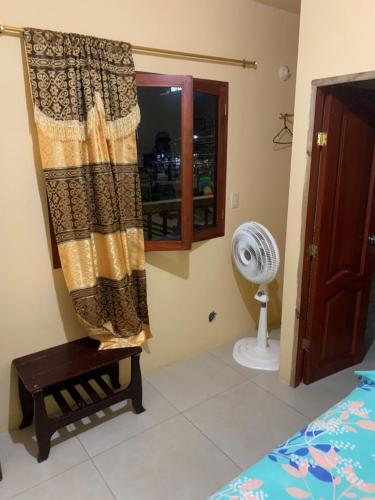 1 dormitorio con 1 cama, ventana y ventilador en Habitaciones cómodas cerca de la playa en Montañita, en Montañita