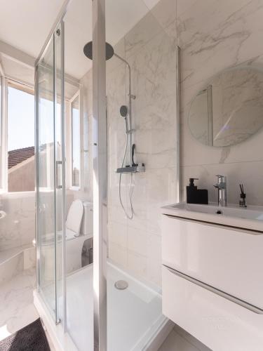 une salle de bain blanche avec une douche et un lavabo dans l'établissement Logement pour 8 personnes près de Disney & Paris, à Chanteloup-en-Brie