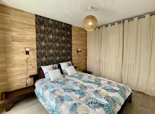 1 dormitorio con 1 cama con edredón azul y blanco en La Marina - Proche Paris & Aéroport CDG, en Sevran