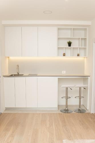a kitchen with white cabinets and a table at SINFONIA LUX in Belgrade