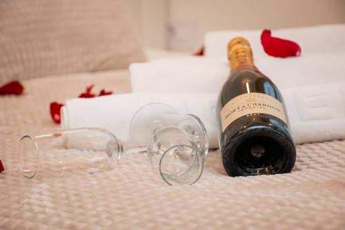 eine Flasche Champagner und Gläser auf dem Bett in der Unterkunft SINFONIA LUX in Belgrad