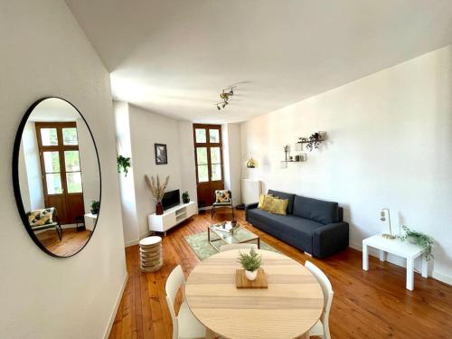 a living room with a table and a blue couch at Le Riquet - 4 people - Hyper Center - Metro in Toulouse