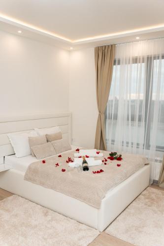 a white bedroom with a bed with roses on it at SINFONIA LUX in Belgrade
