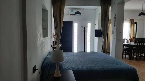 1 dormitorio con 1 cama azul y comedor en Dpto Parke Mitre 1 en Corrientes