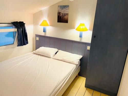 - une chambre avec un lit et deux lampes murales dans l'établissement Duplex 3 piscines (1 chauffée/couverte) 300m plage, à Les Sables Vignier