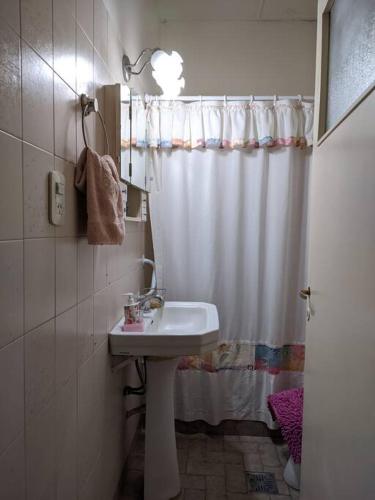 a bathroom with a sink and a shower curtain at Casa en Pigue in Pigüé