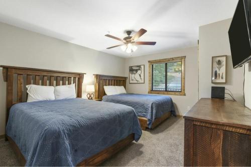 a bedroom with two beds and a ceiling fan at Table Rock Resorts at Indian Point in Branson