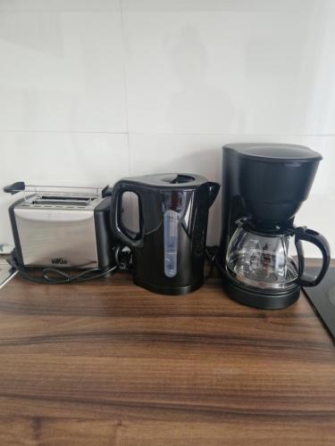 a black coffee maker and a toaster on a counter at M&BLuxux Apartaments in Krefeld