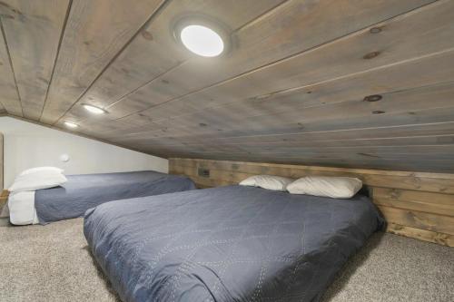 two beds in a room with a wooden ceiling at Table Rock Resorts at Indian Point in Branson