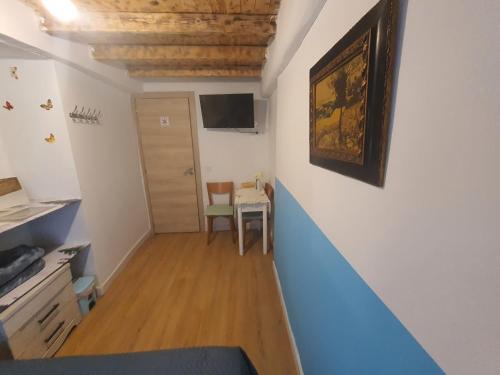 a hallway with a table and a painting on a wall at Habitaciones Casa Santander Playa Valdenoja in Santander