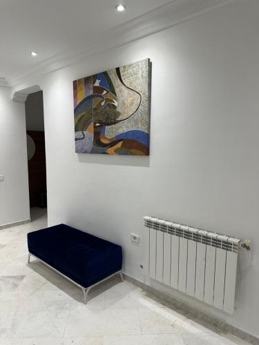 ein Gemälde an einer Wand in einem Zimmer mit einer Bank in der Unterkunft Appartement haut standing 170 m2 in Tunis