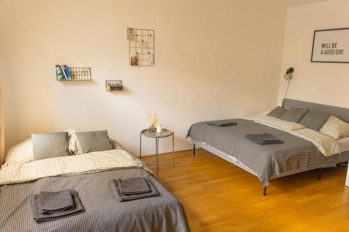 - une chambre avec 2 lits et une table dans l'établissement Modern - Calm - Cozy - self CheckIn - stylish new apartment near center - close to U4, à Vienne