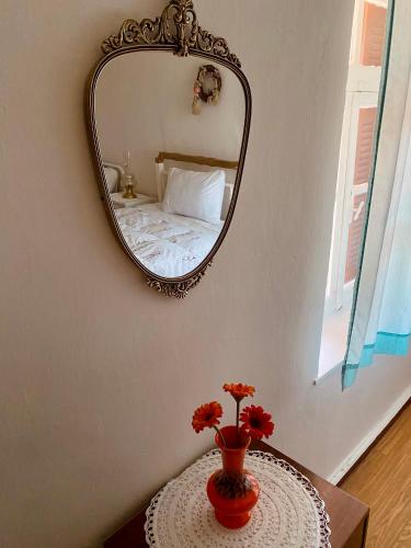 un espejo en una pared sobre una mesa con un jarrón con flores en Pavlianis Cottage House, en Pavliani