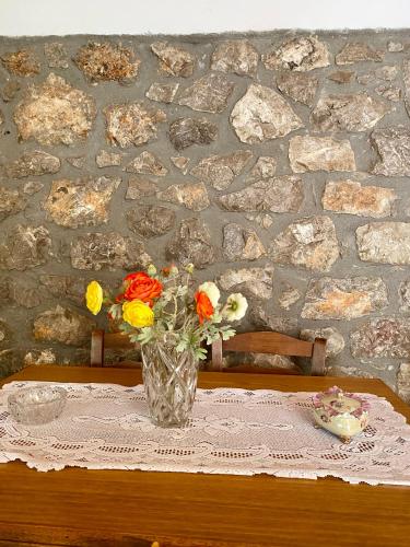 un vaso di fiori seduto su un tavolo di Pavlianis Cottage House a Pavliani