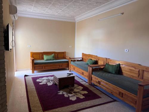 ein Wohnzimmer mit 2 Sofas und einem Tisch in der Unterkunft Dar Chamsa in Tozeur