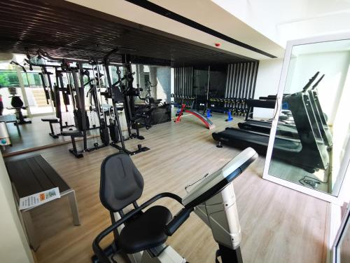 a gym with several tread machines and a mirror at Bangkok Sathon RYE condo in Bangkok
