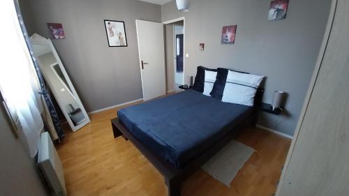 une chambre avec un lit avec des draps et des oreillers bleus dans l'établissement Meublé de tourisme 2* les Jardins de l Arquebuse, à Dijon