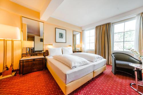 a hotel room with a large bed and a mirror at Hotel Rheinfels in Sankt Goar