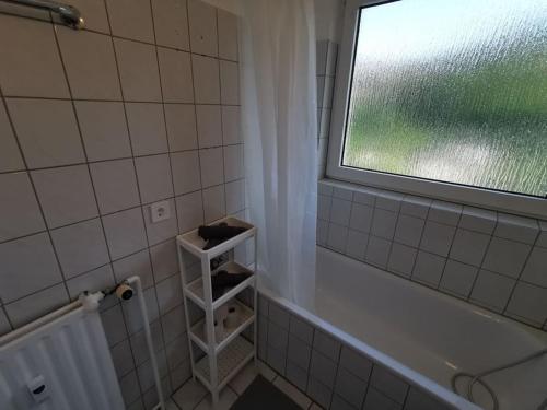 uma casa de banho com uma janela e uma banheira em Bright & Cozy Apartment em Plettenberg