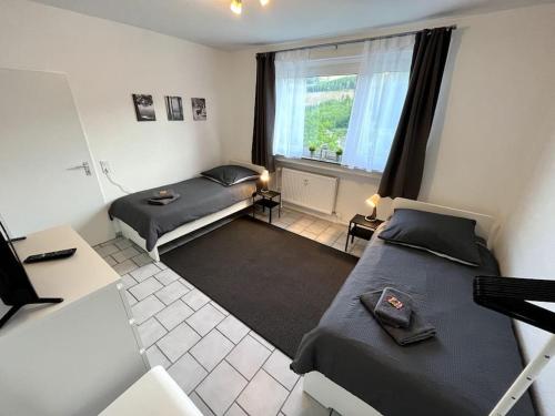 um pequeno quarto com 2 camas e uma janela em Bright & Cozy Apartment em Plettenberg