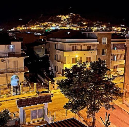B&B Villa Mariotta في أمانتيا: مدينة في الليل مع سيارة متوقفة في موقف للسيارات
