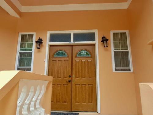 a house with a wooden door and two windows at The Seclusive Mansion in Roseau