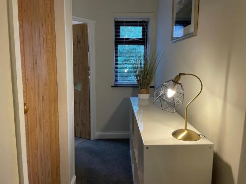 a room with a desk with a lamp on it at Muddy Paws Cottages - The Nook in Taddington