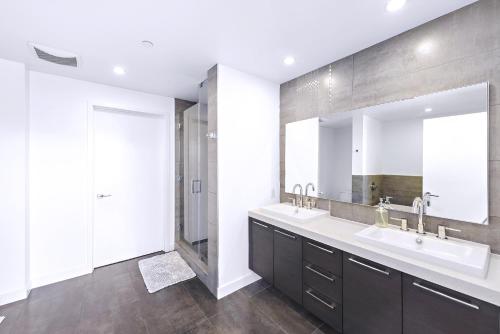 a bathroom with two sinks and a large mirror at Oceanview 25th Floor Luxury Penthouse in Santa Ana