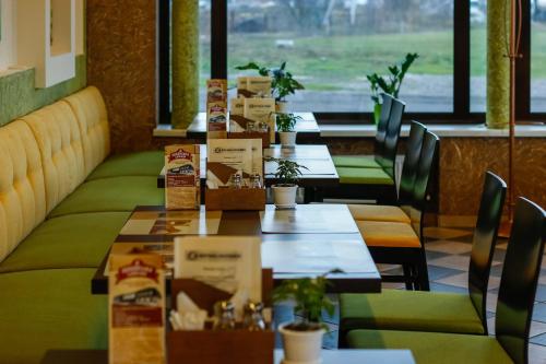 a row of tables in a restaurant with plants at Hotel Lubenska Sloboda in Vilʼshanka
