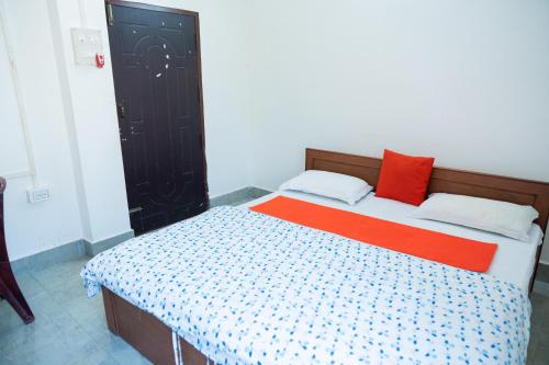 a bedroom with a bed with an orange and blue comforter at JRB RESIDENCY in Dibrugarh