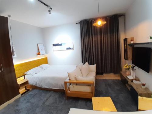 1 dormitorio con cama, sofá y TV en EnN Lovely En suite studio apartment, en Bungoma