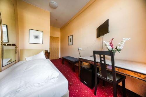 a hotel room with a bed and a desk at Hotel Rheinfels in Sankt Goar
