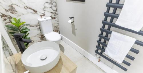 a bathroom with a white toilet and a plant at Modern boutique apartment for 4- central Ellesmere in Ellesmere
