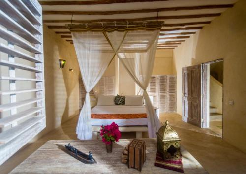 a bedroom with a bed with a canopy at Seaside Villa 1 & Seaside Villa 2 at 'Tamani' in Diani Beach