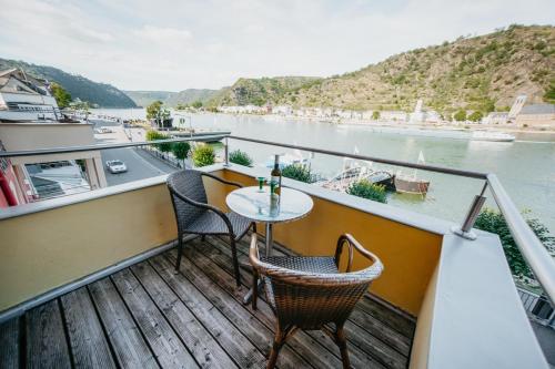 a balcony with a table and chairs overlooking a river at Hotel Rheinfels in Sankt Goar
