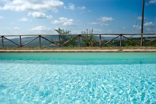 a pool of blue water in front of a bridge at Agriturismo Borgo Malva' in San Venanzo