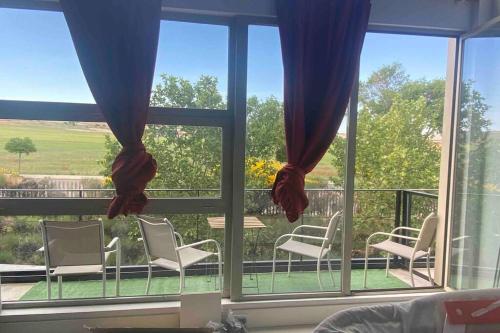 Camarma de EsteruelasにあるVistas al campoの窓とバルコニー(椅子付)が備わる客室です。