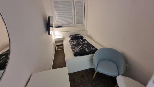 ein kleines Zimmer mit einem Bett und einem blauen Stuhl in der Unterkunft Ubytování na letišti Ostrava Mošnov in Mošnov