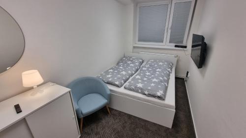 een kleine slaapkamer met een bed en een stoel bij Ubytování na letišti Ostrava Mošnov in Mošnov