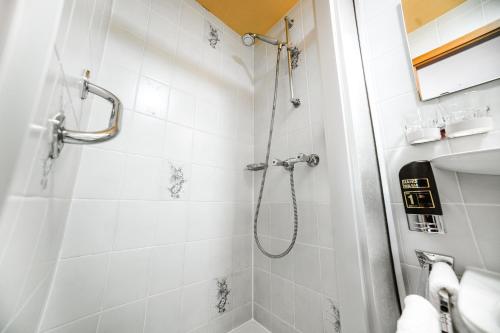 a bathroom with a shower with white tiles at Hotel Rheinfels in Sankt Goar