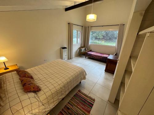a bedroom with two beds and a staircase in a room at Casita Silvestre y Casa Rosa in Villa La Angostura