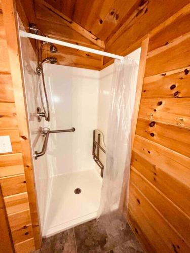 a bathroom with a shower in a wooden wall at Willow Cabin in Thompsonville