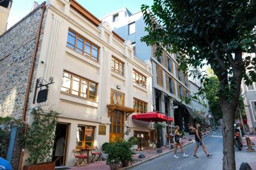 two people walking down a city street with buildings at TAKSİM PERA House in Istanbul