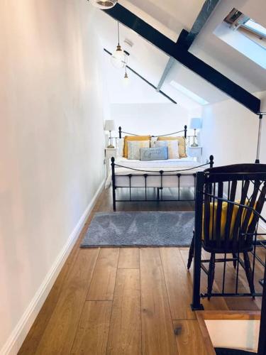a bedroom with a bed and a chair in a room at Adorable Victorian 1 bedroom annexe in Beaumaris