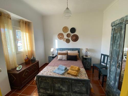 sypialnia z łóżkiem i stołem w obiekcie Buganvilla Alentejo w mieście São Francisco da Serra