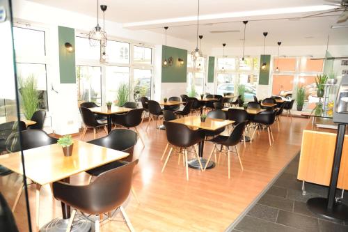 a restaurant with tables and chairs in a room at hogh Hotel Heilbronn in Heilbronn