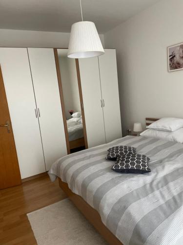 1 dormitorio con 1 cama con lámpara y espejo en Apartman II u centru grada en Kutina