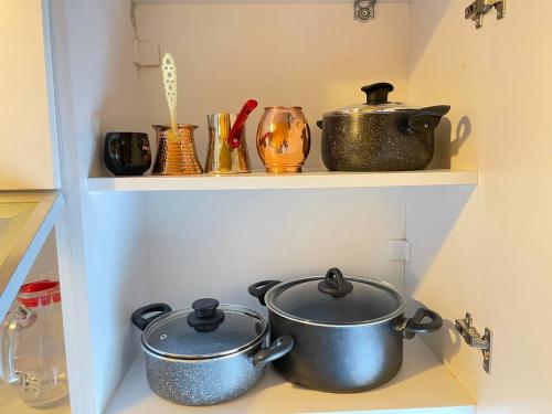 two pots and pans sitting on shelves in a kitchen at TAKSİM PERA House in Istanbul