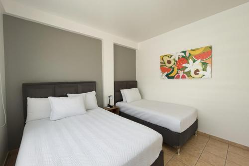 a bedroom with two beds and a painting on the wall at Nuevo! Amplio y Acogedor in Santa Cruz de la Sierra