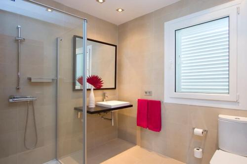 uma casa de banho com uma cabina de duche em vidro e um lavatório. em Villa Coral em Puerto del Carmen